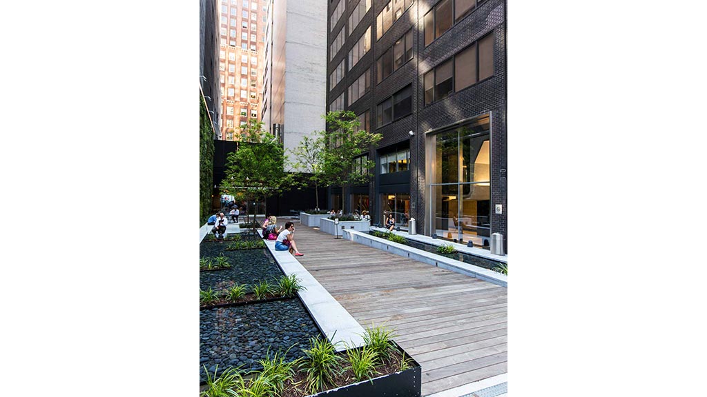 A group of people sitting on the ground outside of High Line.