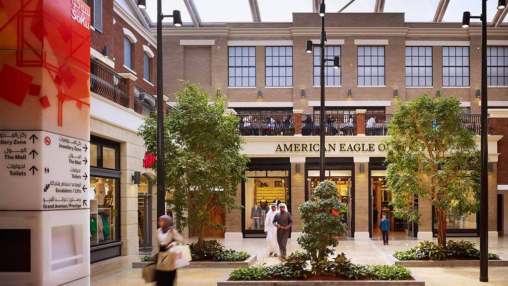 A few people walking outside of a building.