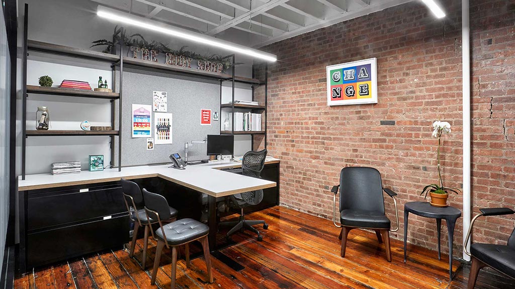 A room with a desk and chairs.