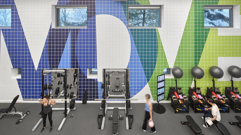 A group of people in a room with exercise equipment.