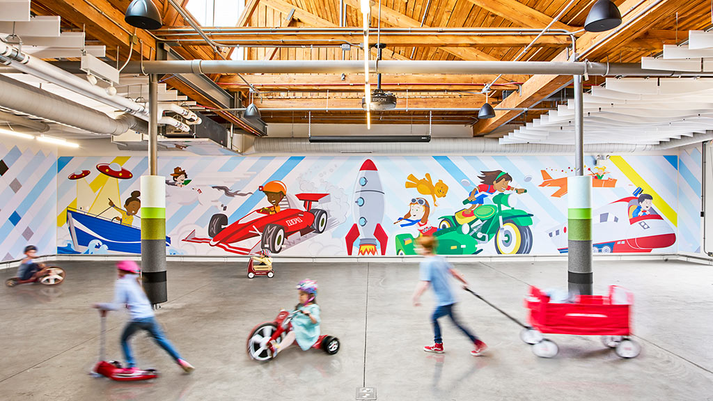 People in a room with a wall of art.