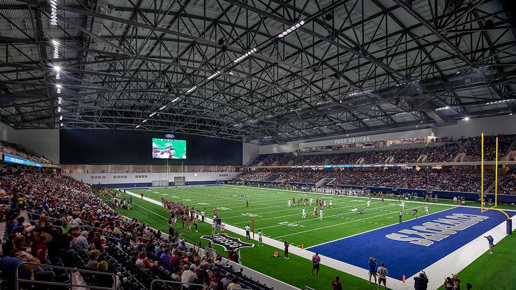 A football stadium with a field and players on the field.