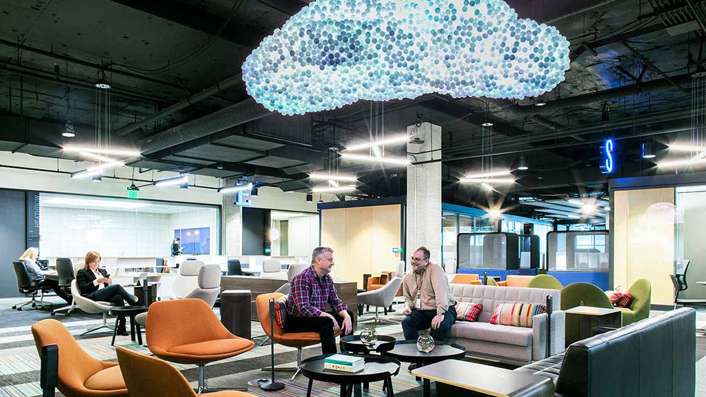 A couple of people sitting in a room with a large umbrella.