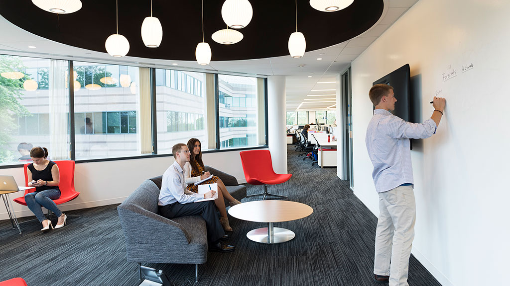 A man standing in a room with a woman sitting on a couch.