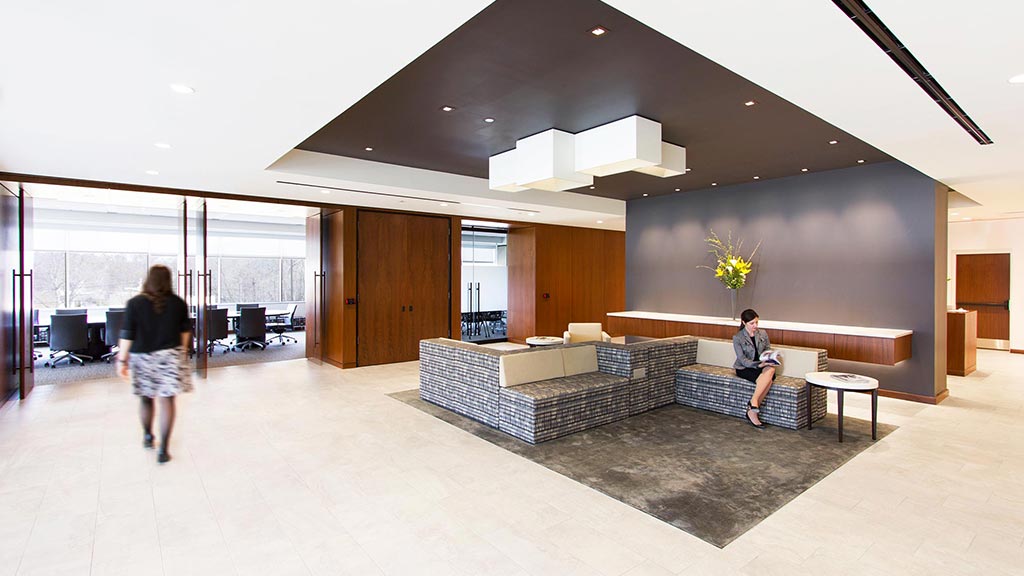 A man and a woman in a room with a large glass wall.