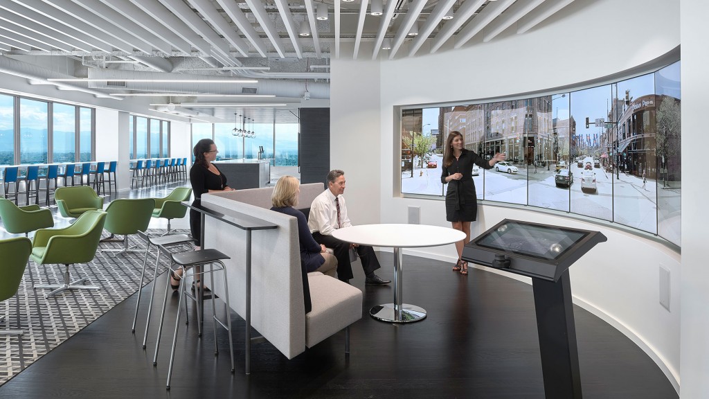 A woman talking to a man seated at a table.