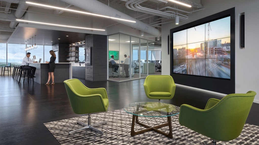 A room with green chairs and a large screen.