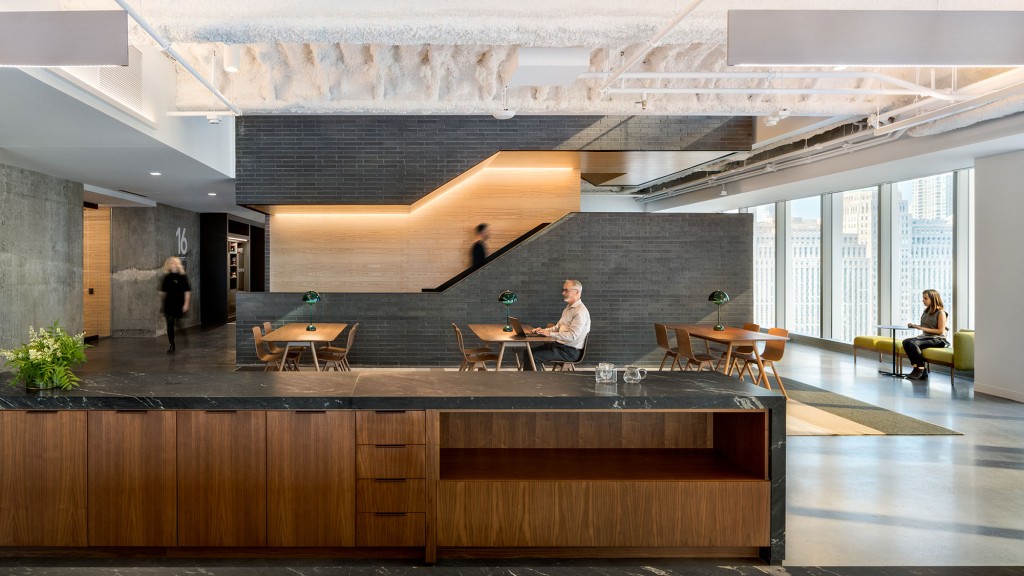 A man and woman sitting at a table in a large room.