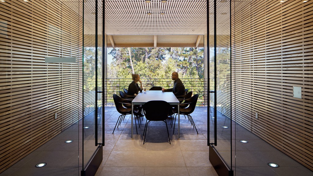 A group of people sitting at a table in a room with a large window.