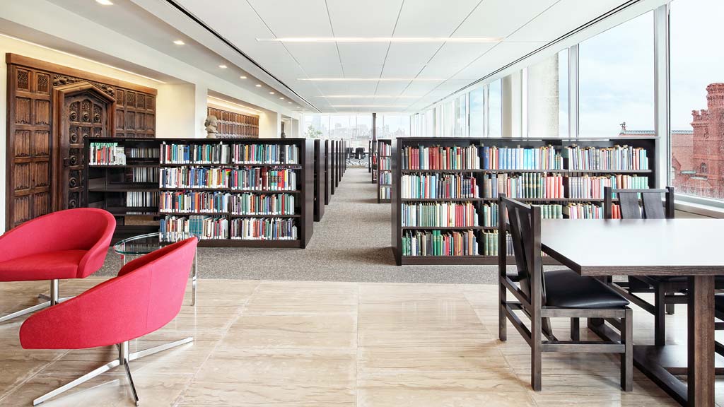 A room with a table chairs and a bookcase.