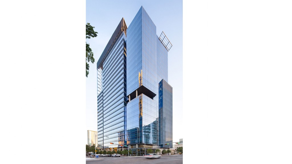 A tall building with a street and cars.