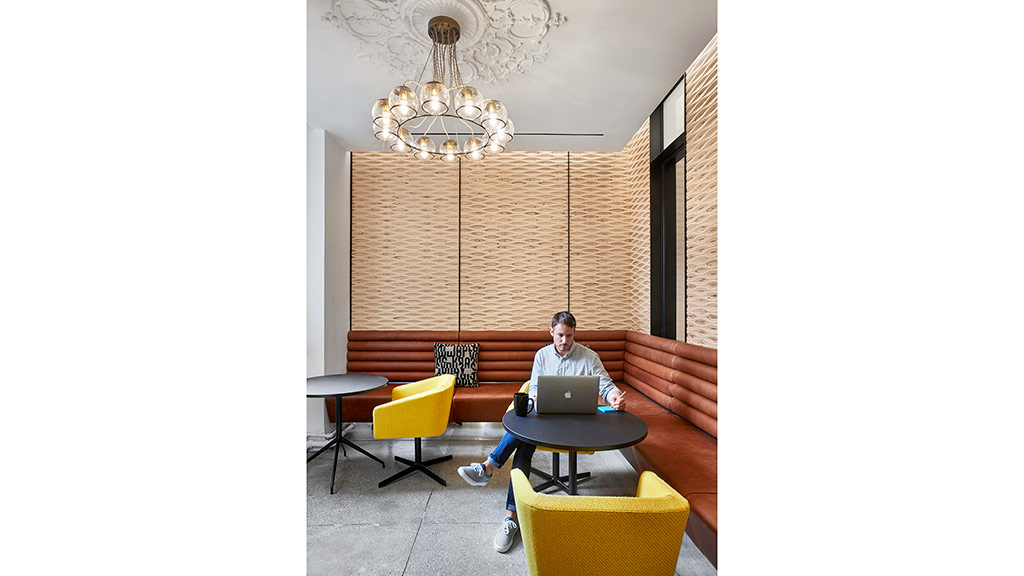 A person sitting on a couch with a laptop.