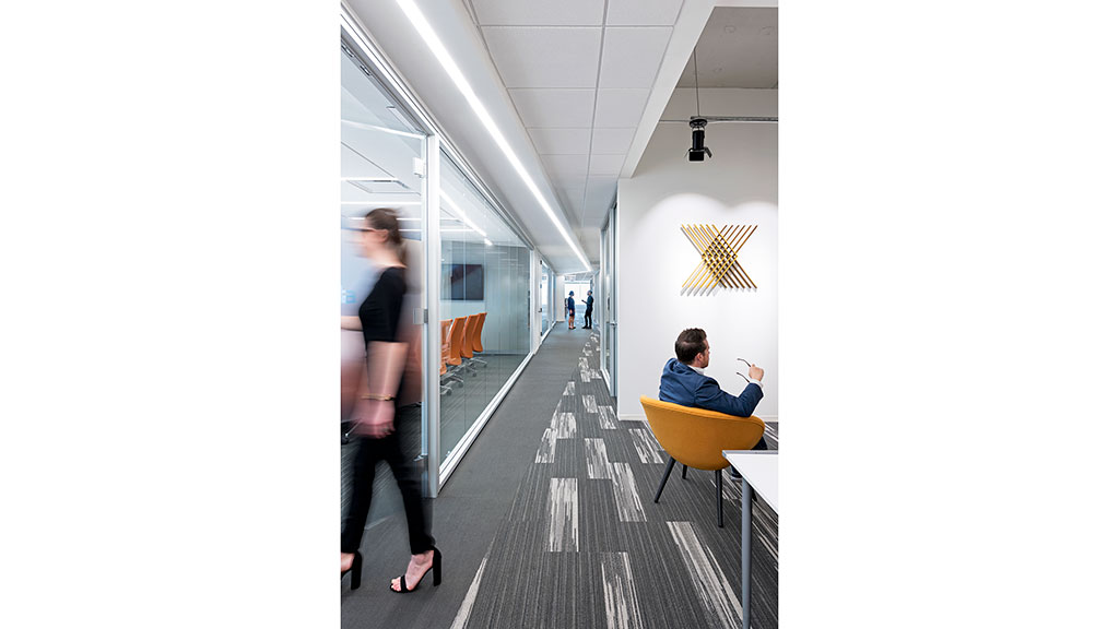 A woman standing next to a man sitting at a table.