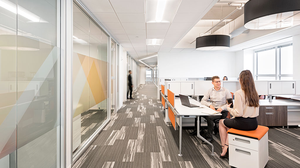A man and a woman sitting at a table in an office.