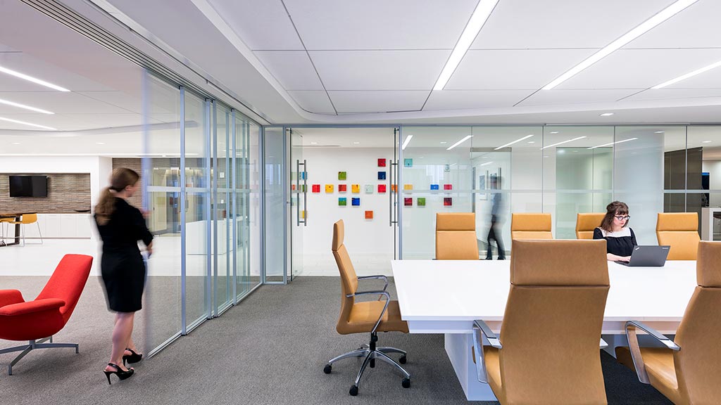 A person standing in a room with a table and chairs.
