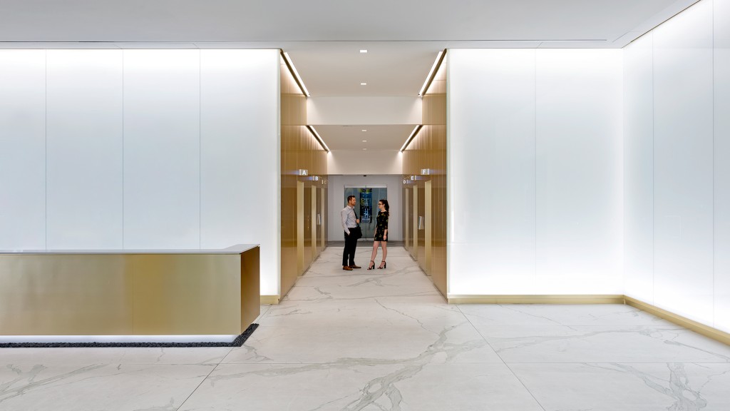 A man and woman walking in a hallway.