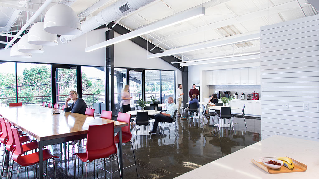 A group of people sitting at a table in a large room.