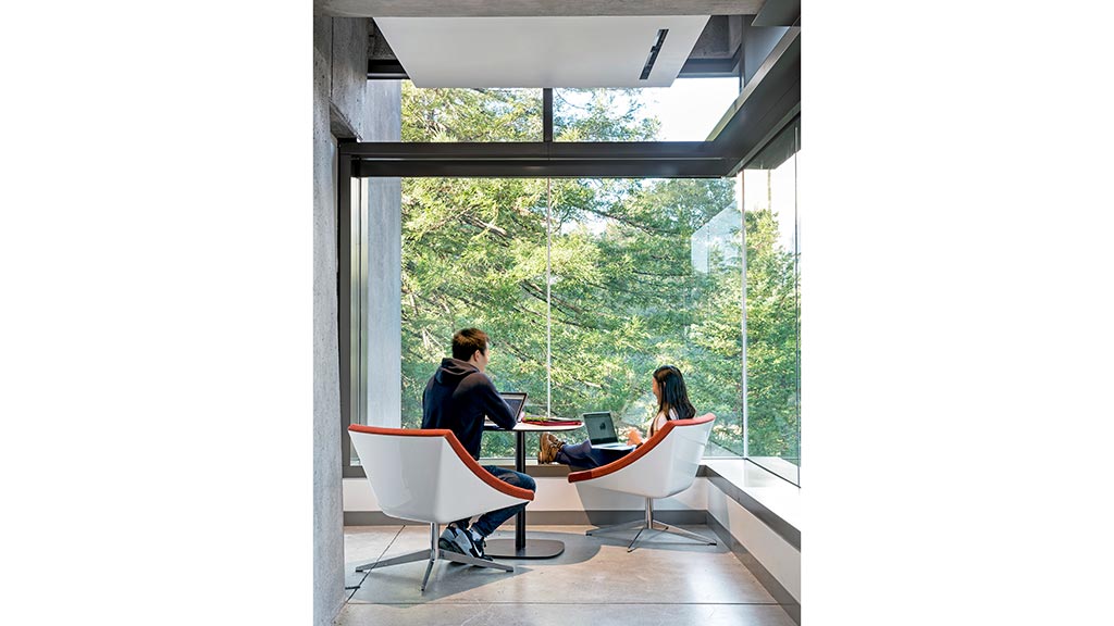 A man and a woman sitting at a table with laptops.