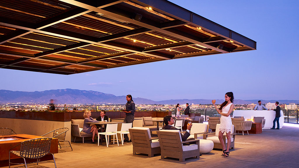 A group of people sitting at tables under a roof.