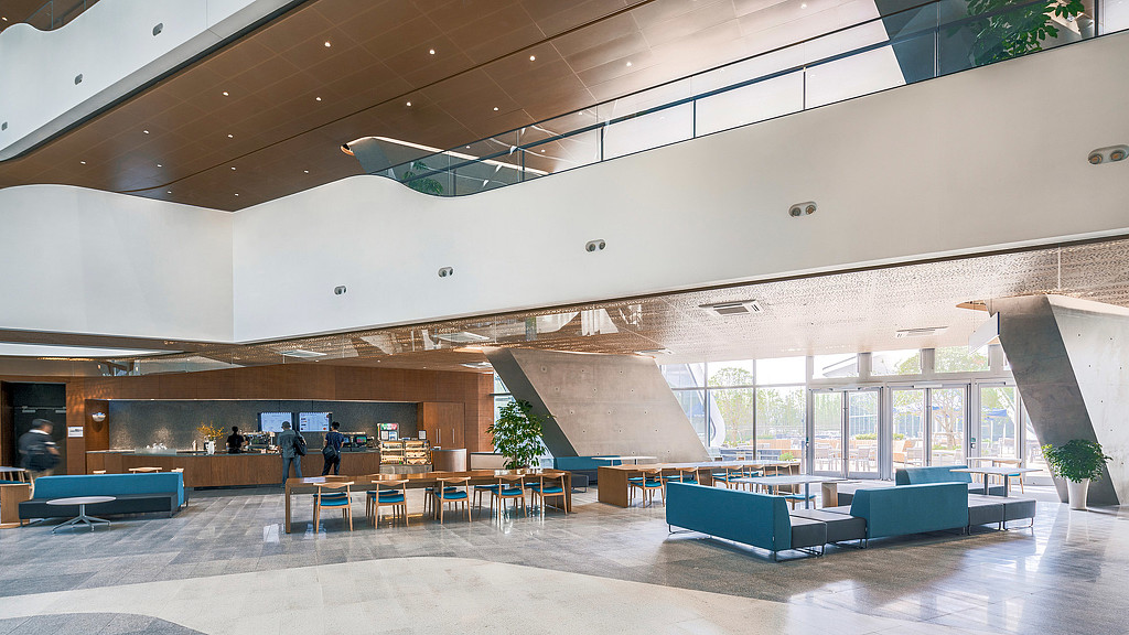 A large room with a few people.