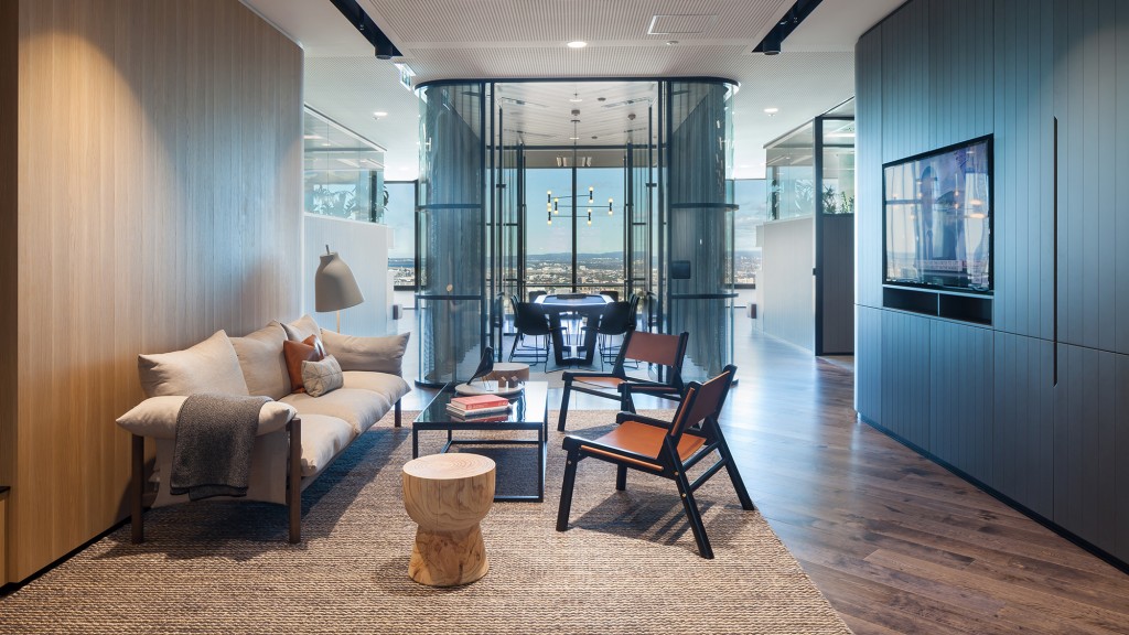 A room with a couch and chairs.