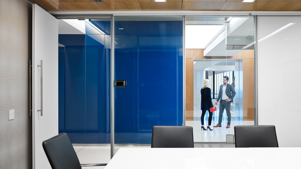 A man and a woman walking through a glass door.