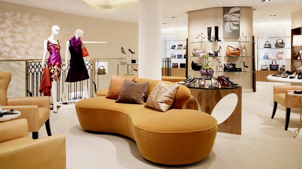 A room with a couch and a table with a chair and a mannequin in it.