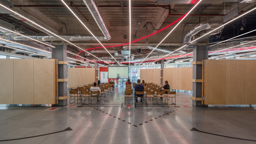 A group of people sitting at a table in a large room.