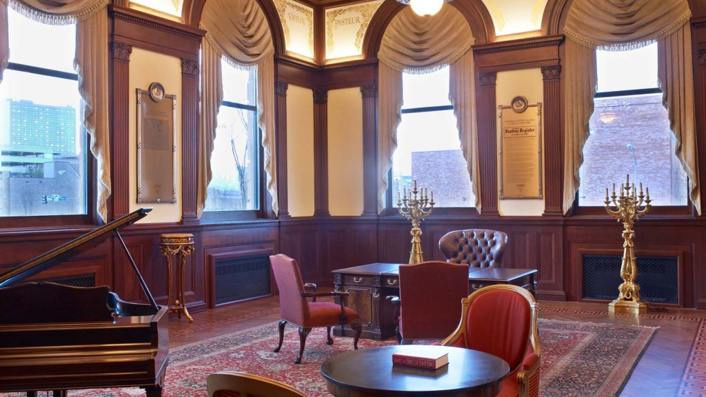 A room with a piano and chairs.