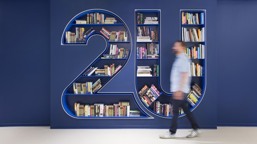 A person standing in front of a book shelf.