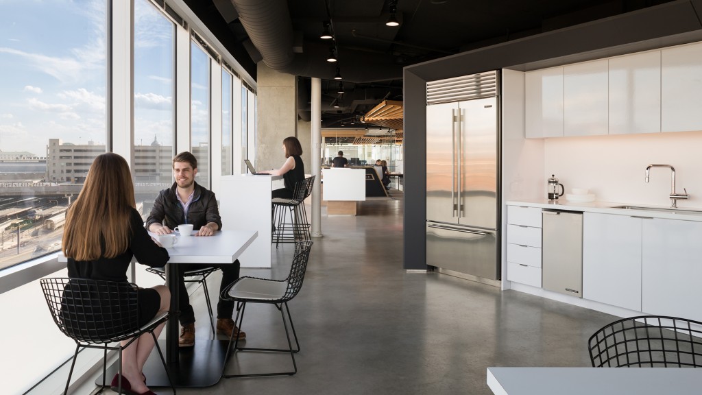 A group of people sitting at a table in a room with windows.