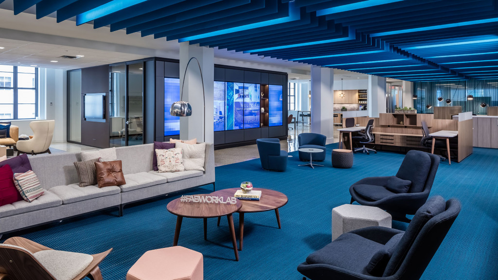 A room with a couch and chairs.