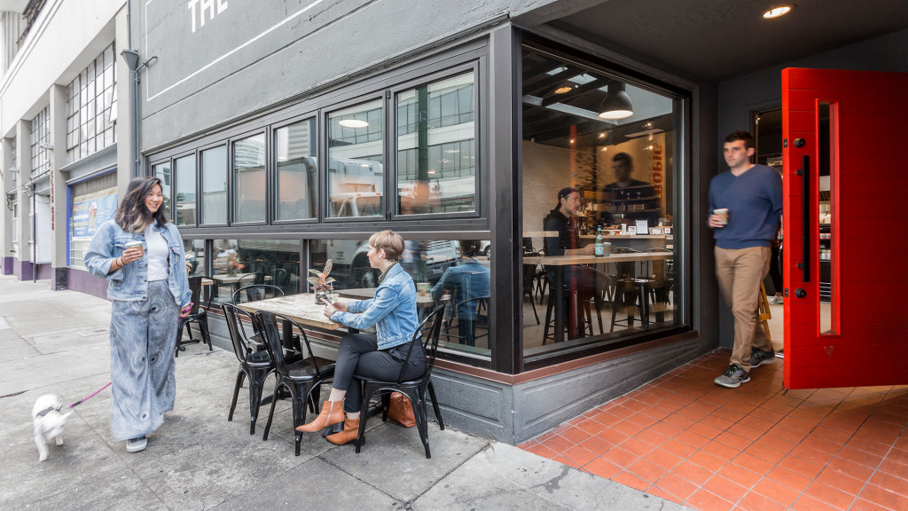 A woman and a man at a table with a dog.