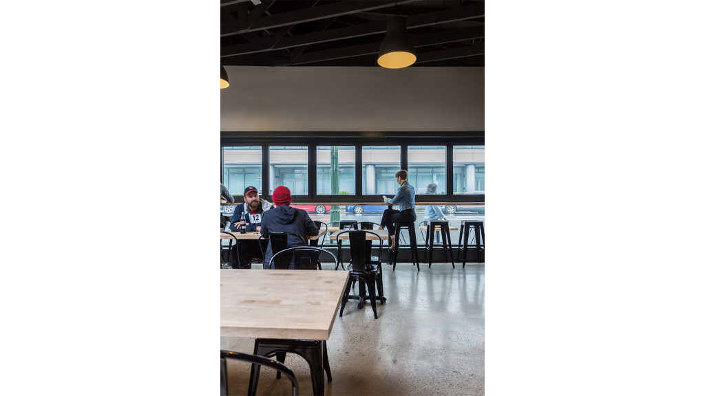 A group of people sitting at a table in a room with windows.