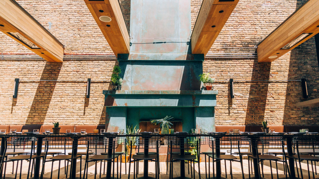 A group of tables and chairs in front of a brick building.