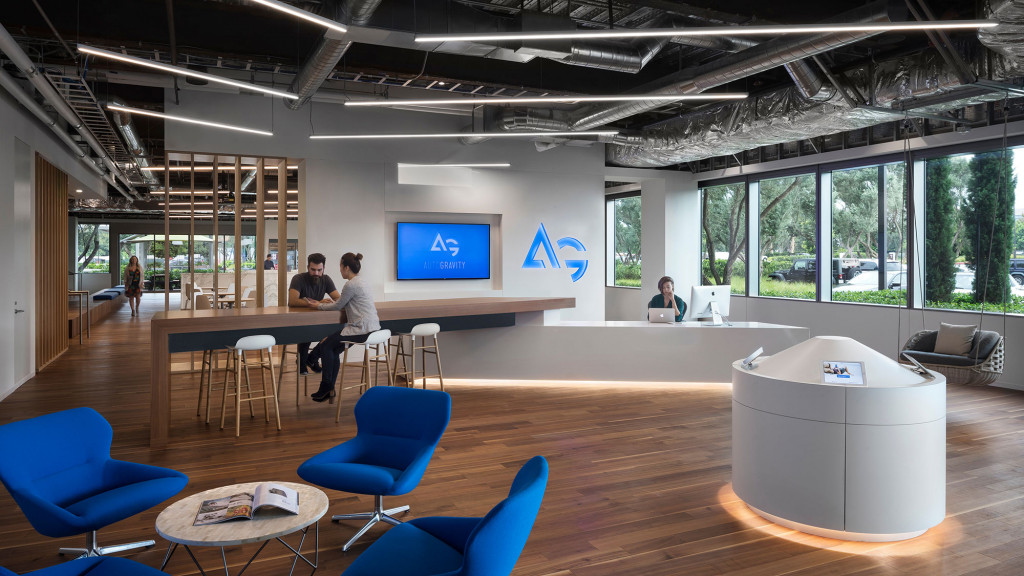 A group of people sitting in a room with a large screen.