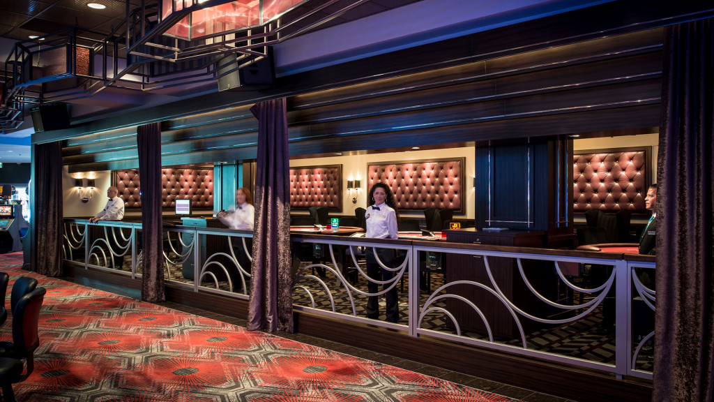 A person standing in a room with a bar and chairs.