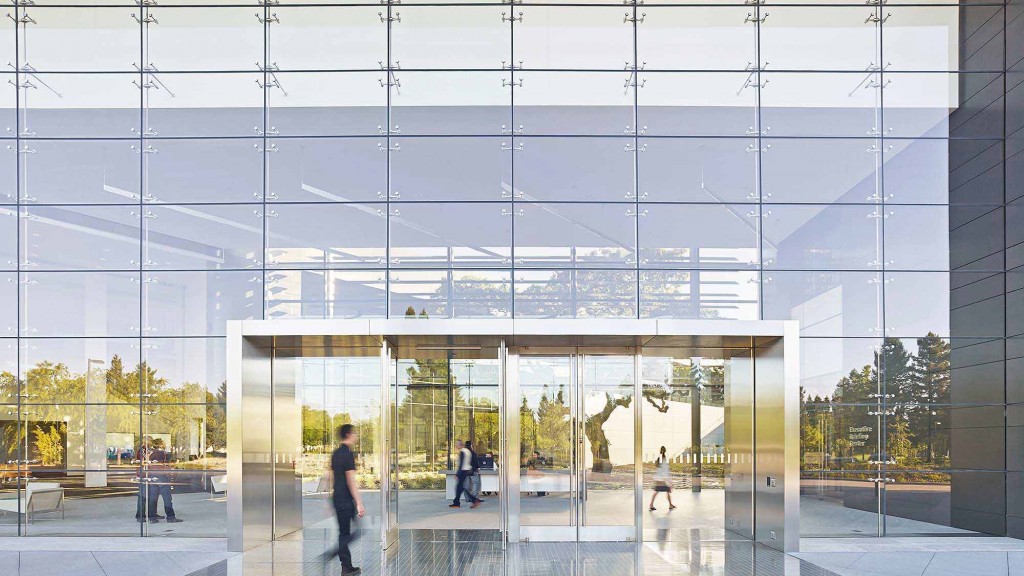 A person standing in front of a glass building.