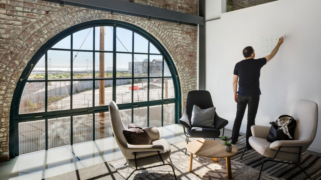 A person standing in a room with a large window.