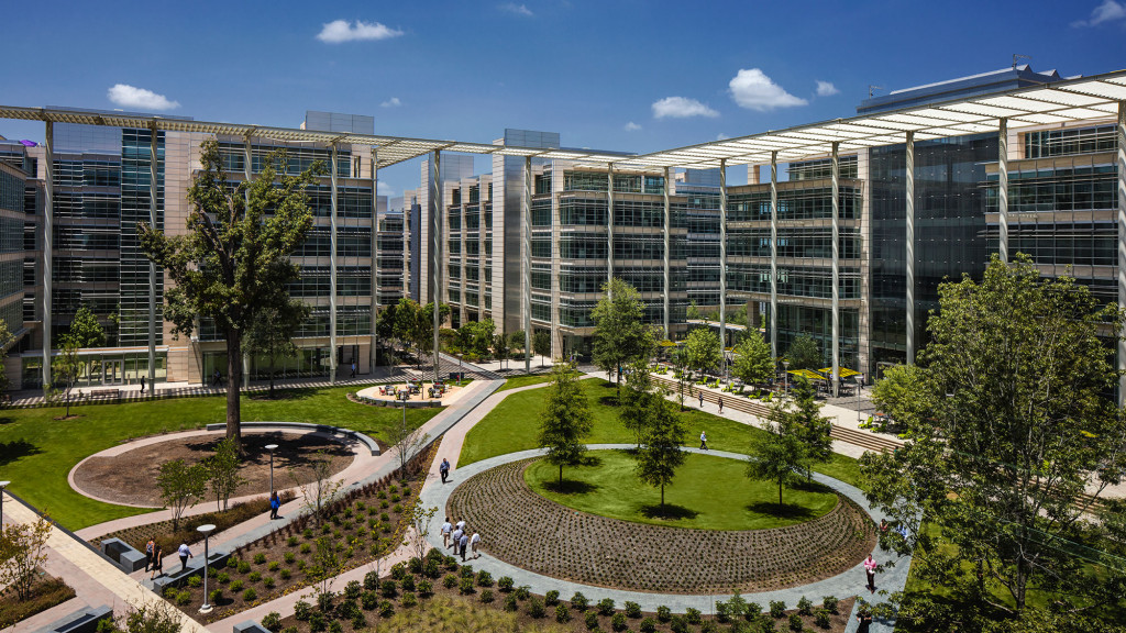 A large building with trees and people walking around.