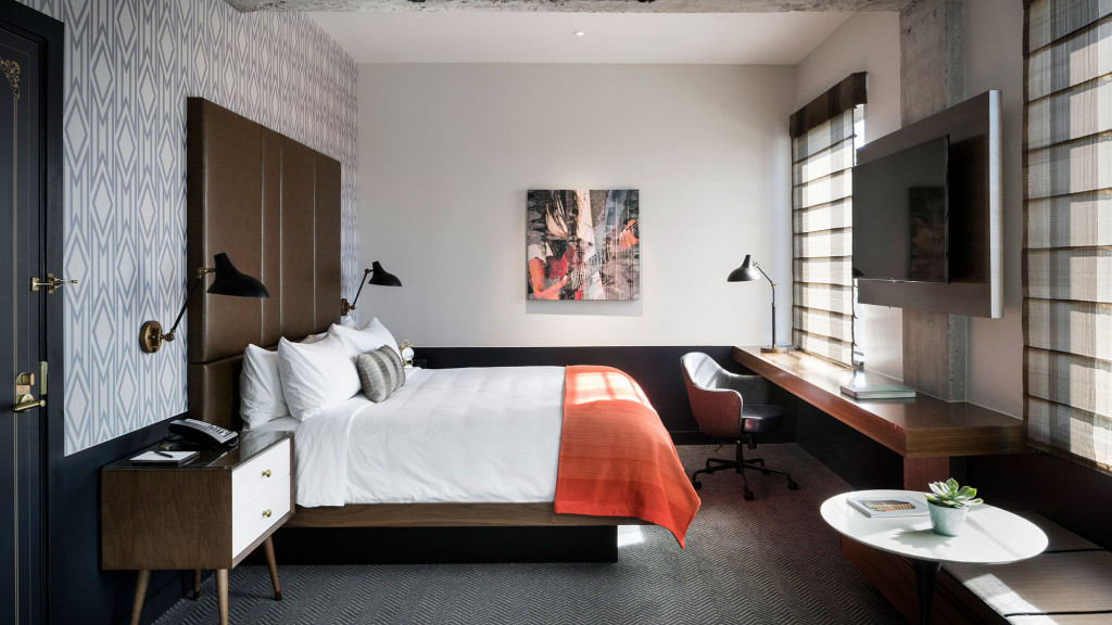 A bedroom with a bed and desk.