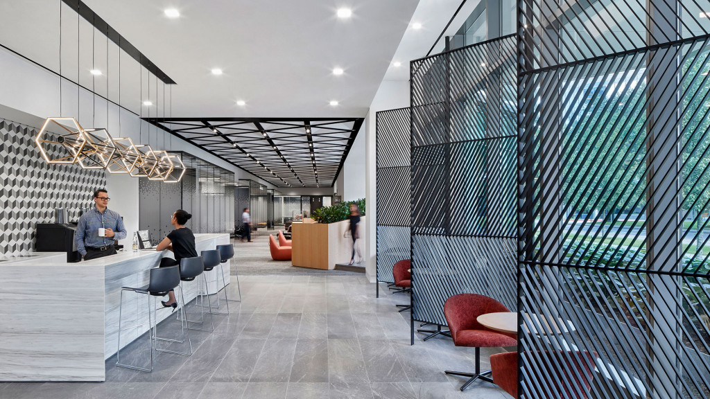 A man and woman sitting at a table in a large office.