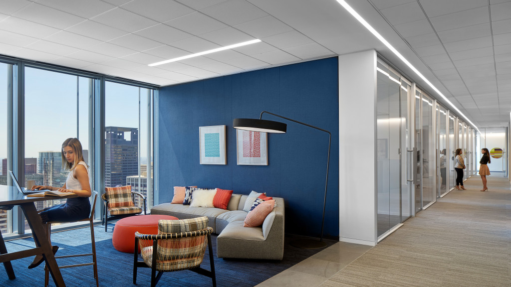 A person sitting at a table in a room with a large window.