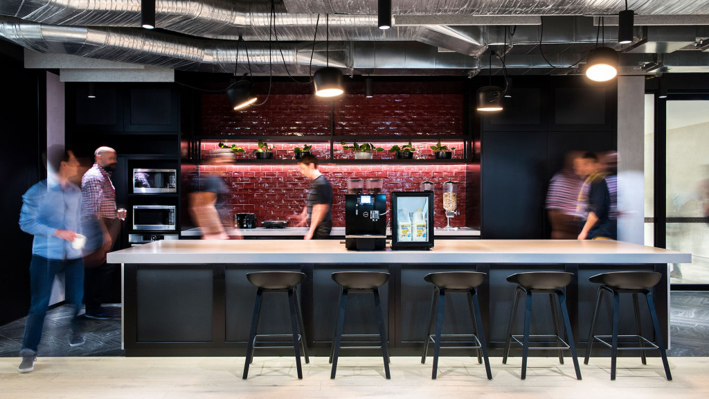 A group of people standing around a bar.
