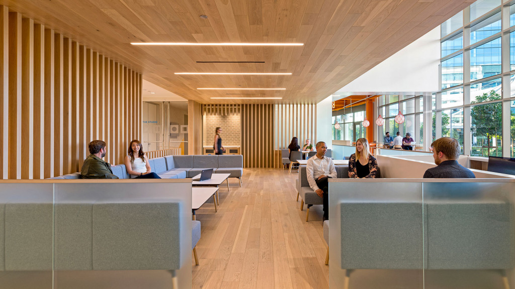 A group of people sitting in a room with a large glass wall.