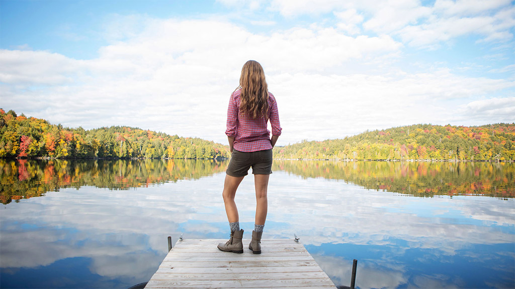 A person standing on a dock over water.
