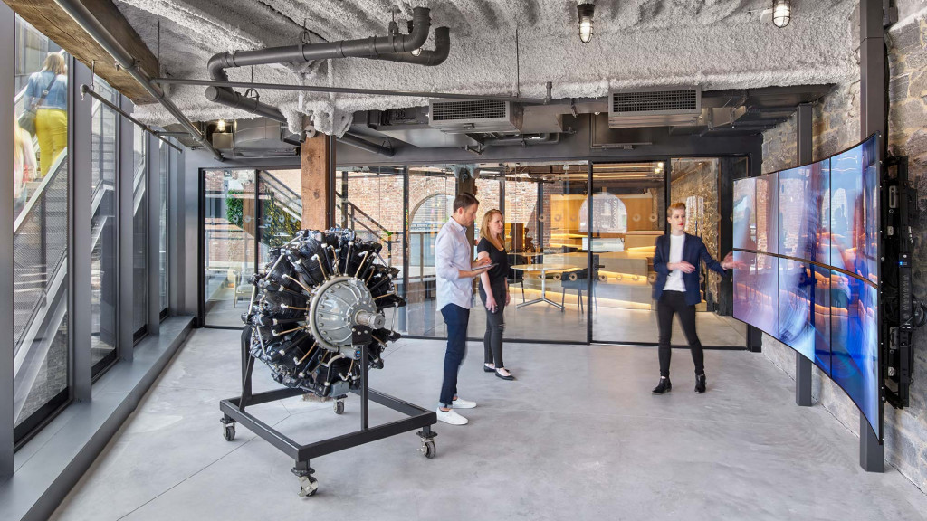 A group of people standing in a room with a large machine.