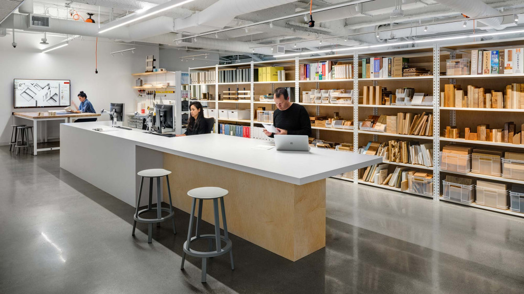 A man and woman working at a table in a library.