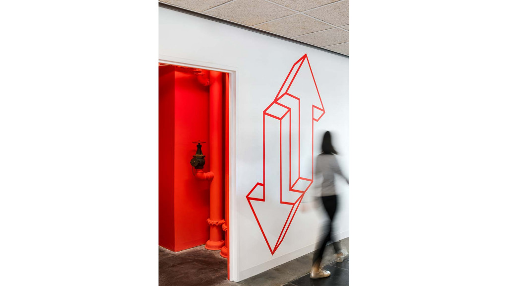 A person standing next to a red door.