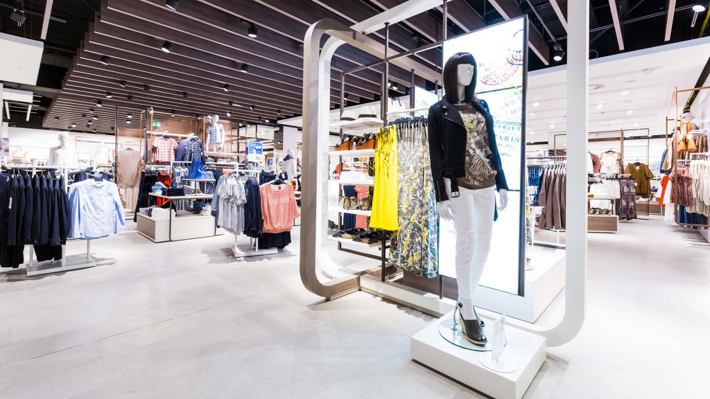 A clothing store with a mannequin in the front.